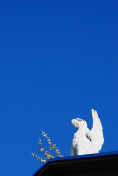 Fragment of winged mythical griffin sculpture on the roof.