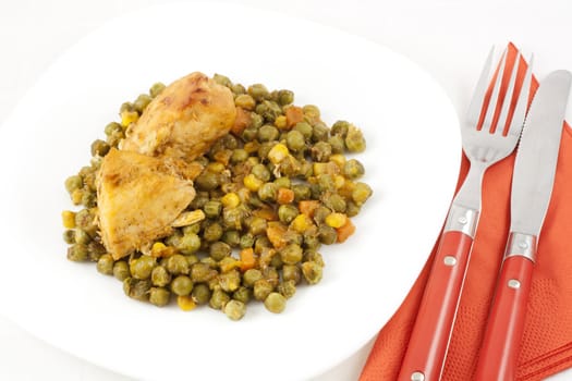 Baked chicken meat with green peas, carrots and corns on table