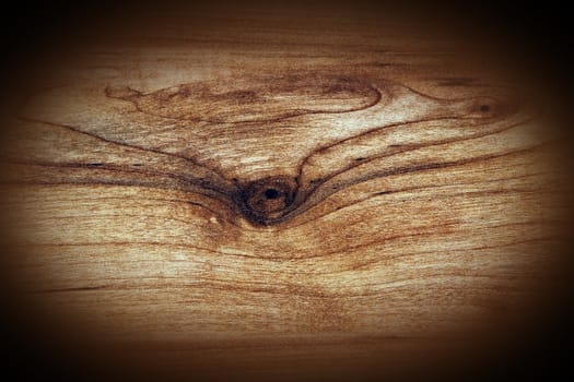 Hard wood plank with knot grungy background with dark vignette.