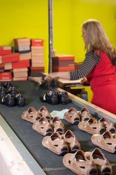 Footwear factory worker at the packaging station