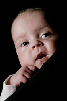 three month old baby is looking over the shoulder