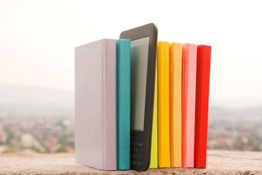 Row of colorful books with electronic book reader