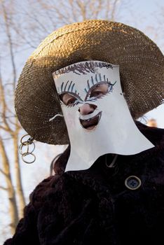 man in disguize with Mardi Gras primitive paper mask