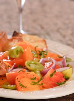 plate of tomato salad with red, green and yellow tomato's, onion and toast