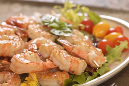 Shrimp lunch on a skewer, with mushrooms, pasta, cauliflower, red peppers, and onions on a Christmas plate.