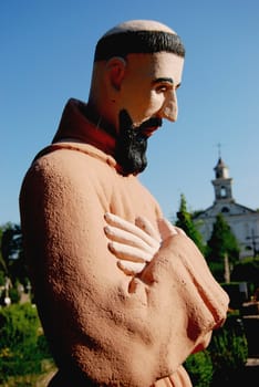 Retro monk sculpture with hands and sky background