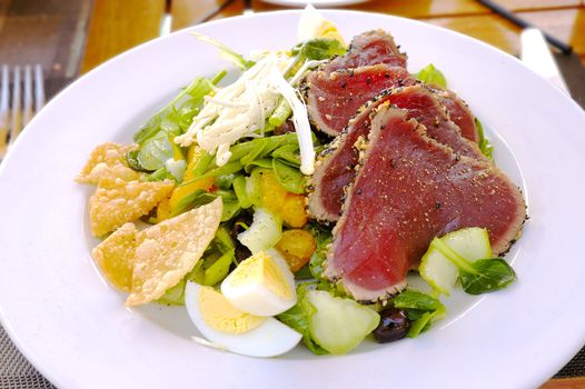 lunch salad with egg, mandarin, salad, sprouts, olives and steak tartar