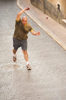 Traditional Spanish pelota player performing a serve