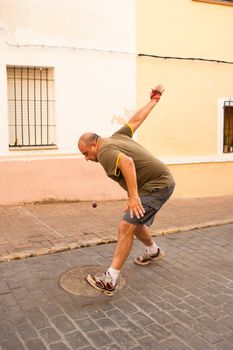 Traditional Spanish pelota player performing a serve