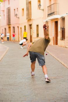 Traditional Spanish pelota player performing a serve