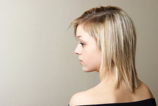 A profile shot of a young attractive woman with copyspace in the direction of her eyes.