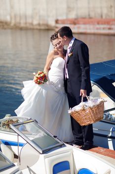 bride and groom kissing on the pier