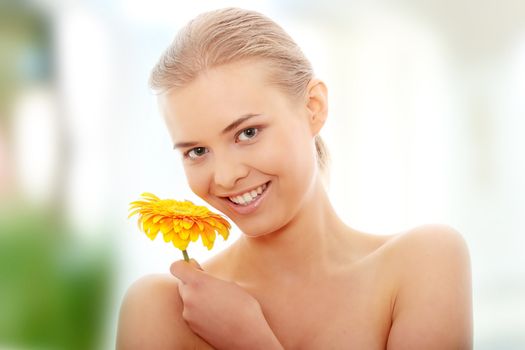 Portrait of the attractive girl without a make-up, with flower in hand, isolated on white background