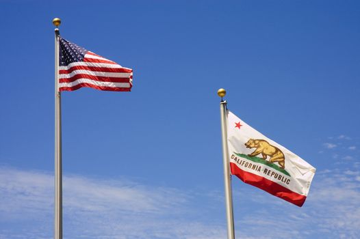 US and California Flags flying against a blue sky