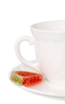 White tea cup and slices of fruit candy