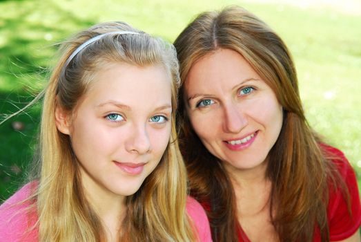 Portrait of a smiling mother and teenage daughter in summer park