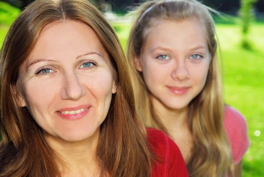 Portrait of smiling family of mother and her teenage daughter