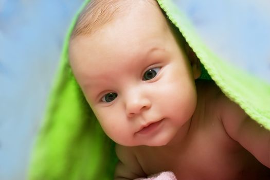 Baby under green towel