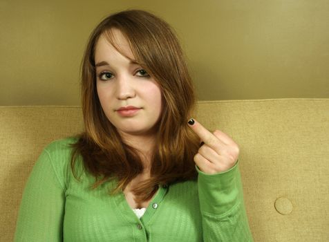 A young teen female with rebellious attitude, giving the finger.
