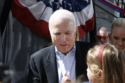 John McCain gets picture taken with little girl.