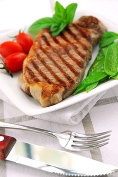 Grilled New York steak served on a plate with vegetables