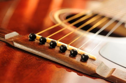 Acoustic guitar bridge and strings close up