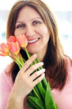 Smiling mature woman holding bouquet of flowers