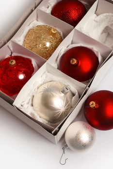 Various Christmas balls resting in a box waiting to be placed on the tree.
