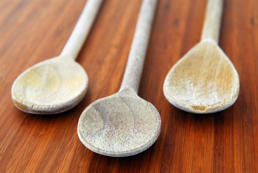 Old wooden cooking spoons on a cutting board in a kitchen