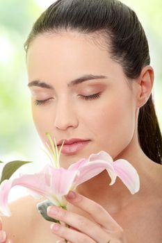 Portrait of the attractive girl without a make-up, with lily flower in hand