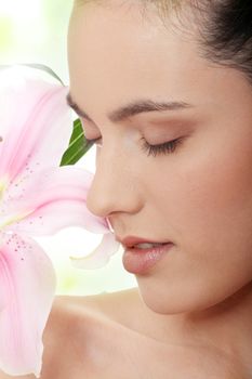 Portrait of the attractive girl without a make-up, with lily flower in hand