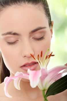 Portrait of the attractive girl without a make-up, with lily flower in hand