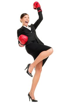 Winning business woman celebrating wearing boxing gloves and business suit. Winner and business success concept photo of young multiracial Asian Caucasian businesswoman isolated on white background.