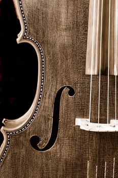 Sepia closeup of a cello on a black background