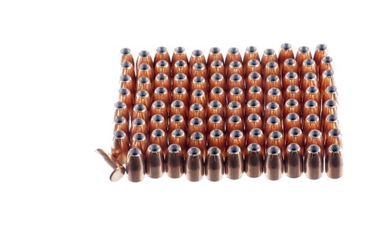 9mm hollow point bullets lined up ready for reloading, with one laying on its side as a odd man out