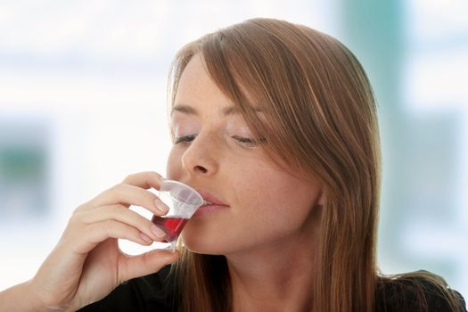 Young woman taking pills and syrup, isolated on white