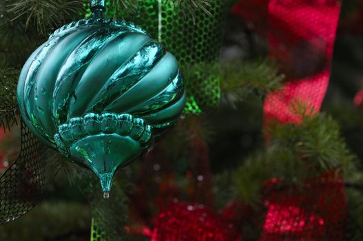 variety of Christmas tree ornaments on an outdoor tree also adorned with lights
