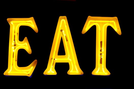 Neon sign with the word "Eat" over black