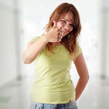 Young woman showing OK. Looking at camera and smiling.