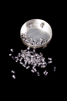 tin of airgun pellets on a black background