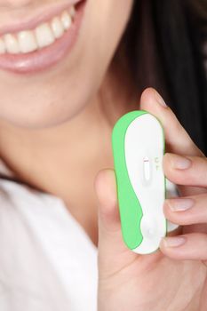 Smiling woman holding a pregnancy test