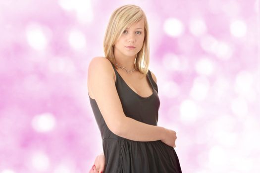 Beautiful teenager young blond girl in black elegant dress over abstract background