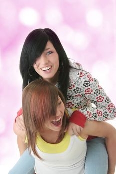 Studio shot of two beautiful happy young woman (sisters)