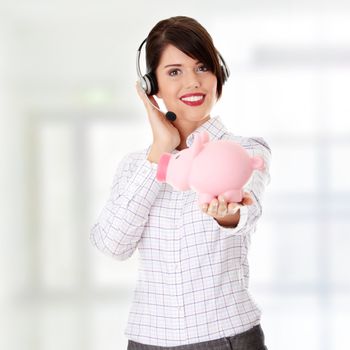 Young business woman with headset holding piggy bank