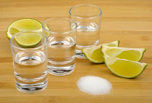 tequila, lime and salt on a wooden background