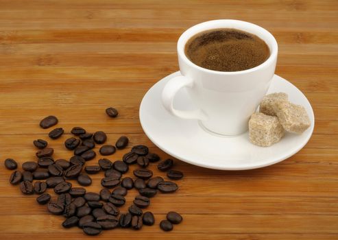 coffee, sugar cane and coffee beans on a wooden background