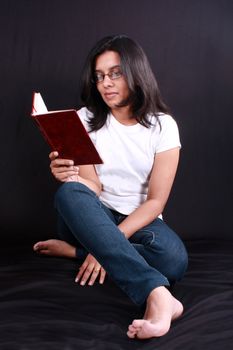 A studious Indian girl reading a book.