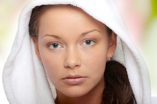 Beautiful young caucasian woman in bathrobe after bath calm portrait.