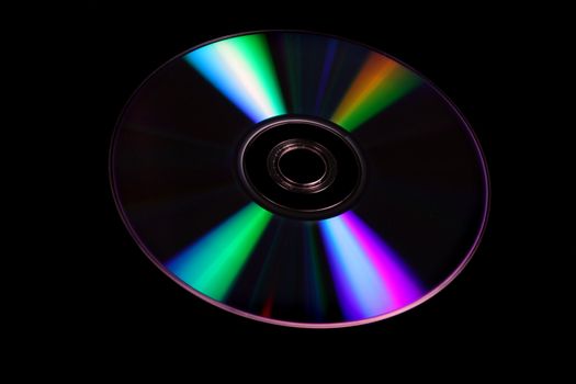 A DVD disc, isolated on black studio background.