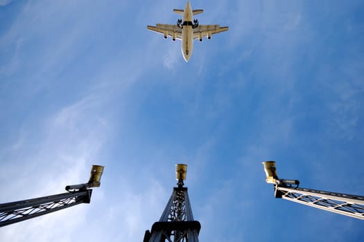 A plane is flying over landing lights in airport. Note the plane is in motion blur and not in focus.